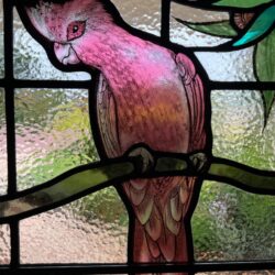 Close-up detail of meticulous hand-painted kiln-fired stained glass artwork showcasing traditional shading techniques by Kim Fitzpatrick.